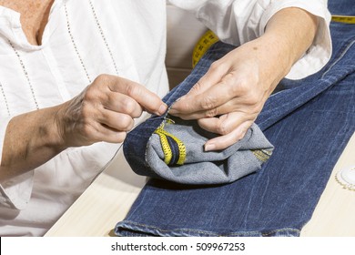 person working,seamstress woman sews the bottoms of the pants