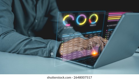 A person works on a laptop displaying futuristic digital charts and graphs with vibrant data visualizations and analytics overlays.