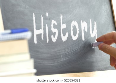 A Person Writing In A Blackboard During History Class In A School. 