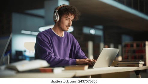 Person Writing in Notebook. Focus Switching to a Thoughtful College Student Using Laptop Computer for Studying in a Library. Handsome Man Learning Online, Getting Ready for Exams - Powered by Shutterstock