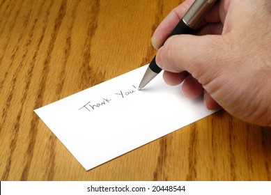 Person Writing Thank You Note With Pen On Card