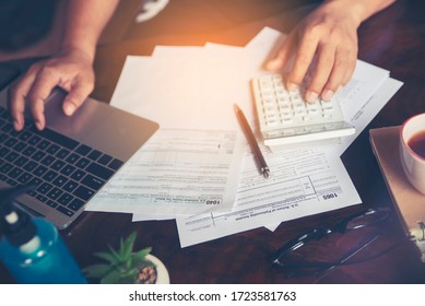 Personal Annual Tax Forms And Calendar 2021 For Individual Income Under US Law Placed On Office Desk. Budget Planning Concept. Accountant Calculating Tax And Using Laptop, Work Online At Home.