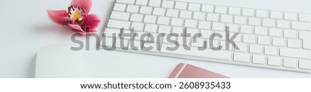 Personal Brand image of a Flat-Lay creative image including one pink pink orchid flower, a partial section of a white keyboard, computer mouse, and a rose gold smartphone. LinkedIn banner crop.