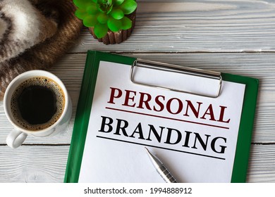 PERSONAL BRANDING - text in a notebook with a pen, a cactus, a cup of coffee and a fragment of a brown plaid. Business concept