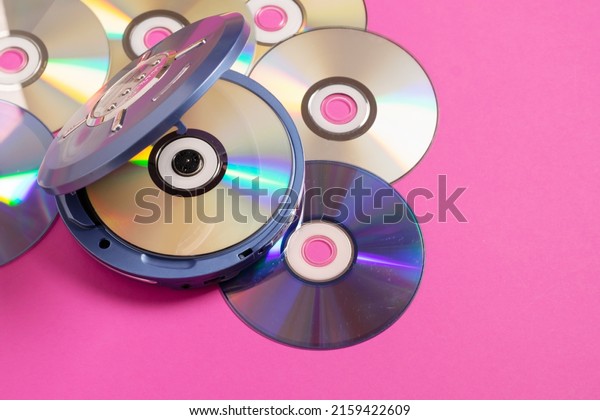 Personal compact portable CD player discs bright\
pink background. Top\
view