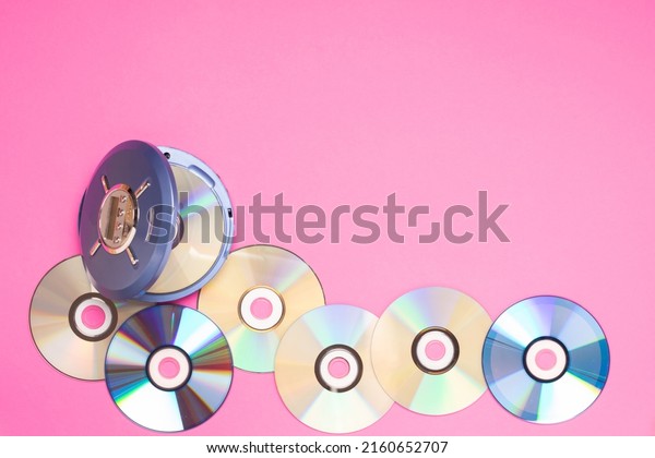 Personal compact portable CD player\
discs on a bright pink background. Top view, copy space, space for\
text or advertising. Hobby entertainment\
rest