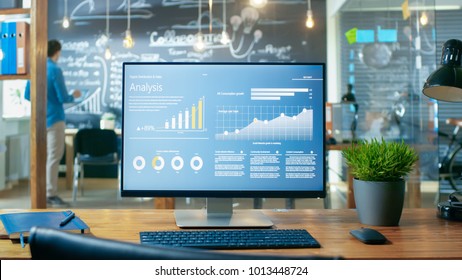 Personal Computer with Mobile Application Design Showing on the Monitor Stands on the Office Desk, In the Background Man Working in the Daytime Office Environment. - Shutterstock ID 1013448724