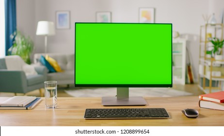 Personal Computer With Mock-up Green Screen Display Standing On The Desk In The Cozy Home Office Living Room Of Prominent Designer.