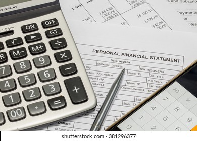 Personal financial statement document, calculator, pen and smartphone