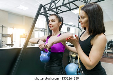 Personal fitness trainer coaching and helping client woman making exercise with weight in gym. Fitness, sport, training, people, healthy lifestyle concept - Powered by Shutterstock