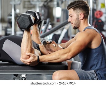 Personal Fitness Trainer Helping A Man At A Chest Workout With Heavy Dumbbells