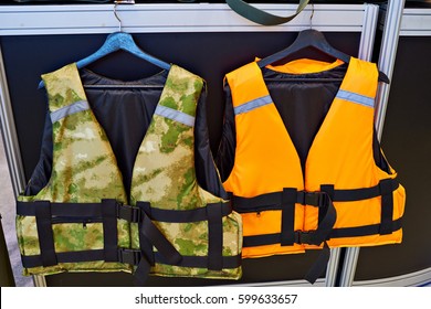 Personal flotation device as a life jacket in store. Orange and green