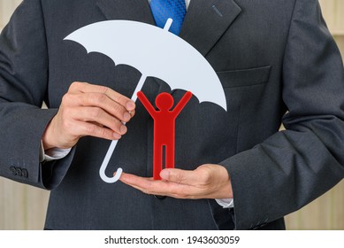 Personal or general data protection, privacy law concept : Businessman with umbrella protects a red doll, depicts protecting client from using of personally identifiable information e.g sensitive data