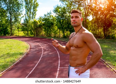 Personal Handsome Shirtless Trainer With Stopwatch During Training Timing A Runner