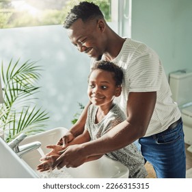 Personal hygiene keeps you clean and prevents illnesses. Shot of a father helping his son wash his hands at a tap in a bathroom at home. - Powered by Shutterstock