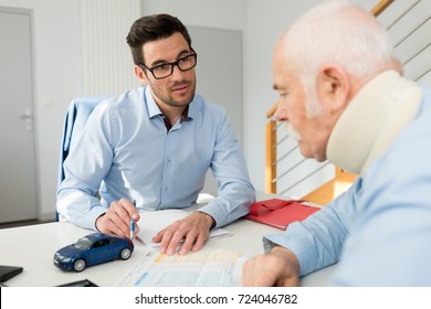 Personal Injury Lawyer In Meeting With Client Wearing Neck Brace