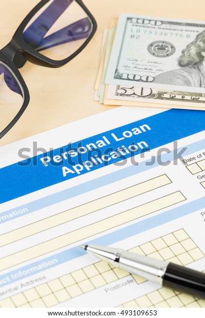 Personal loan application form with glasses dollar\
money, and pen