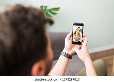 Personal perspective of a man in his 30s calling by video call his friend. Young woman smiling and talking on a video chat