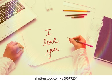 Personal Perspective Of A Young Man Writing Love Letter: I Love You. White Desk With Color Filters And Flair.