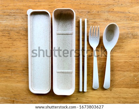 personal plastic utensils set on wooden table. use personal set of utensil to prevent a spreading of disease, covid-19.