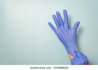 Personal Protective Equipment Blue Vinyl Disposable Gloves, Woman Puts Her Hands In Gloves, Copy Space