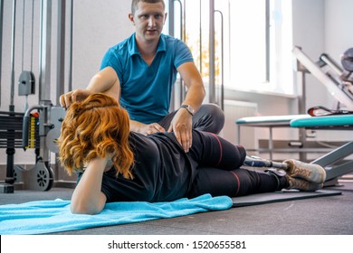 Personal trainer assisting woman with disabilities in her workout. Sports Rehab Centre with physiotherapists and patients working together towards healing. - Powered by Shutterstock