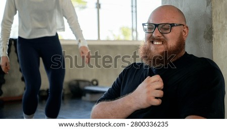 Personal trainer checking on an exhausted beginner who experienced shortness of breath and chest pain from fatigue after strenuous exercise