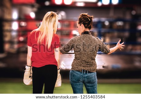 personal trainer coach woman and boxer engaged in boxing in the gym. battle planning and fight rehearsal concept. Valuable instructions before the decisive fight in the ring.light blur