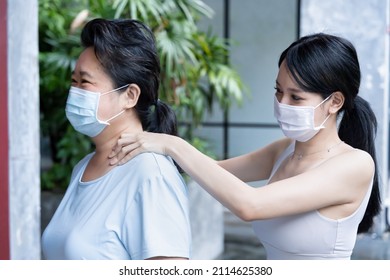 Personal Trainer With Face Mask Massaging Senior Woman Stiff Muscle To Relieve Office Syndrome