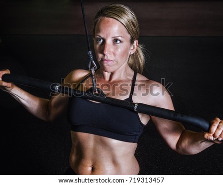 Similar – One young athletic woman at crossfit training, exercising with trx suspension fitness straps over dark background, front view, looking at camera