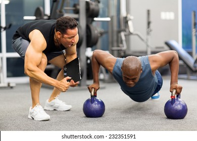 personal trainer motivates client doing push-ups in gym