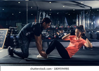 Personal trainer to practice sit-ups in the gym