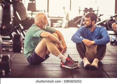 Personal Trainer And Senior Man Talking At Gym After Exercise.