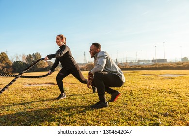 Personal Trainer Training A Girl With Ropes On The Outside