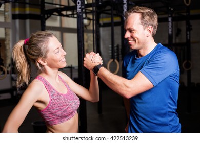 Personal trainer and woman after workout showing strength - Powered by Shutterstock