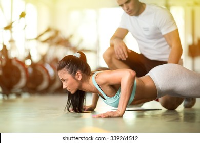 Personal trainer working with his client in gym