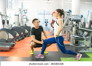 Personal Trainer Working With His Client In Gym.