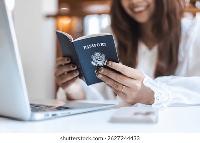 Un momento de investigación de viajes personales con una mujer con pasaporte cerca de la computadora portátil sonriendo feliz mientras planea su próximo viaje