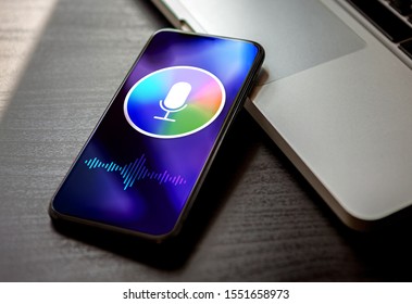 Personal voice assistant concept, deep learning siri sound recognition application on mobile phone screen. Close-up smartphone with microphone icon and wave sound symbol.