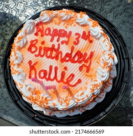Personalized orange creamsicle ice cream birthday cake with whip cream and sprinkles.