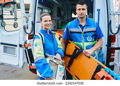 Personnel Of Emergency Service With First Aid Medical Equipment Rushes To Help Victim. Emergency Medical Technicians Near Ambulance