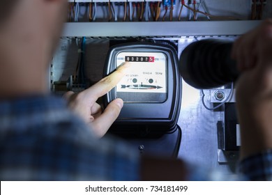 Person's Finger Pointing To Electric Meter Reading Using Flash Light - Shutterstock ID 734181499