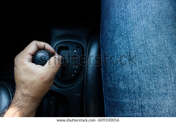 Person\'s Hand Changing Gear While Driving Car.hand\
shifting the gear\
stick