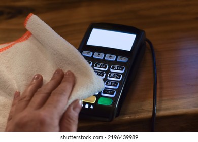 Persons Hand Cleaning Payment Terminal At Retail Store