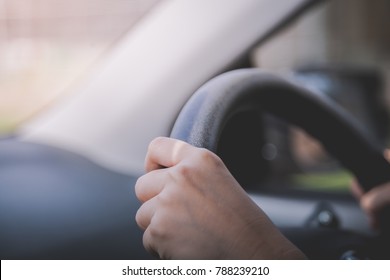 Person's Hand Holding Car Steering Wheel While Driving A Vehicle For Traveling 