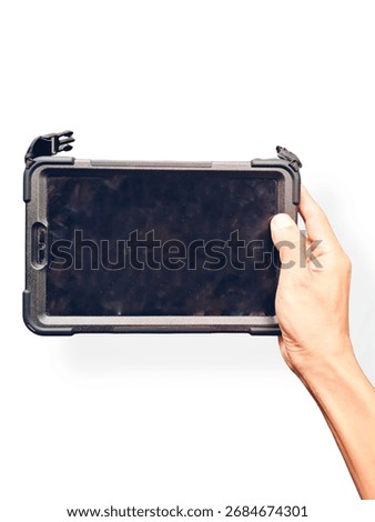 A person's hand holds a tablet computer horizontally. The tablet is encased in a thick, rugged black protective case, designed for durability.