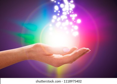 A Person's Hand Into Magical Healing Energy Field With Multi Colored Glowing Lights