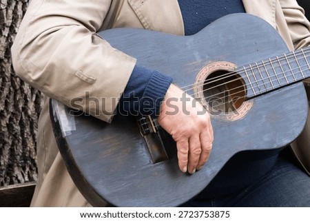 A person's hand on the strings of a guitar.