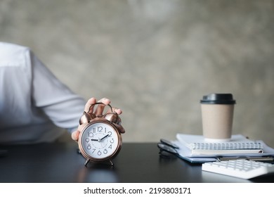 A Person's Hand Presses The Desk Clock To Turn Off The Alarm, He Is Lying Down During A Break During Work Hours To Relax. The Idea Of Taking A Break During The Working Day.