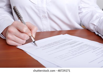 person's hand signing an important document